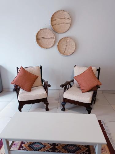 two chairs and a table with two mirrors on the wall at Pecan Farm Guesthouse in Louis Trichardt