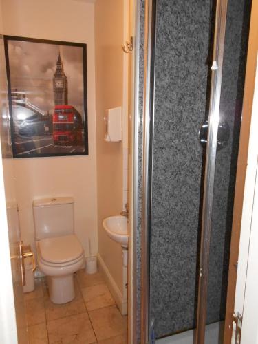 a bathroom with a toilet and a picture of a bus at 24/7 London Hostel in London
