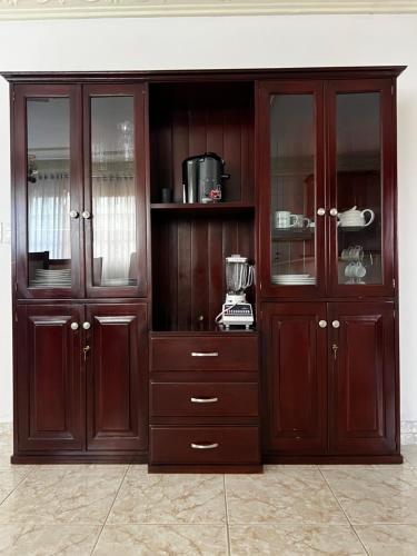 a large wooden cabinet with glass doors in a room at Casa Deisy in Santiago de los Caballeros