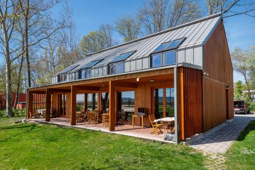 バラトンフレドにあるGolden Bridge Roomsのガラスドアと窓のある大きな木造家屋