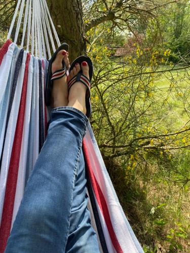 a person laying in a hammock with their feet up at Sznureczki in Przewóz