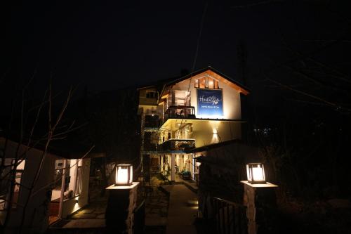 un bâtiment avec des lumières sur son côté la nuit dans l'établissement Hostelgia, à Manali