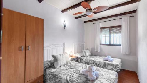 a bedroom with two beds and a ceiling fan at Casa Gonzalez Villanueva de la Concepcion by Ruralidays in Villanueva de la Concepción