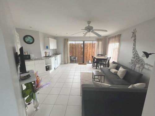 ein Wohnzimmer mit einem Sofa und einer Giraffe an der Wand in der Unterkunft San Lukas Guest Apartment in St Francis Bay