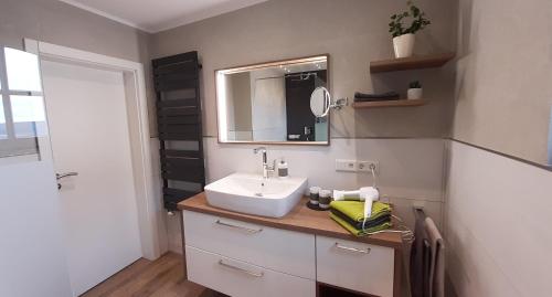 uma casa de banho com um lavatório e um espelho em Sommersonne em Warstein