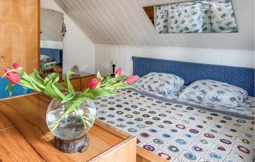 a bedroom with a bed with a vase of flowers on a table at Nice Home In Lidzbark Warminski With House A Panoramic View in Lidzbark Warmiński