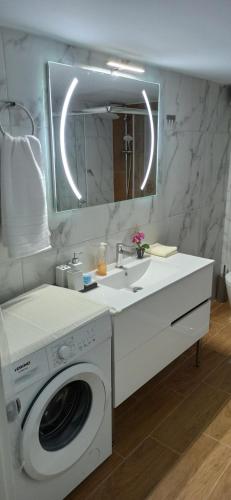 a bathroom with a washing machine and a sink at Cleopatra's Vacation Home in Sparti