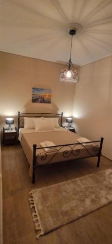 a bedroom with a large bed and two lamps at Cleopatra's Vacation Home in Sparti