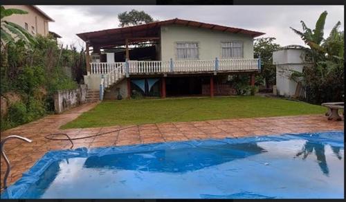 ein Haus mit einem Pool vor einem Haus in der Unterkunft SITiO SONHO DE CRIANÇA in Santa Luzia