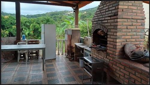 y cocina con horno de ladrillo y vistas. en SITiO SONHO DE CRIANÇA en Santa Luzia