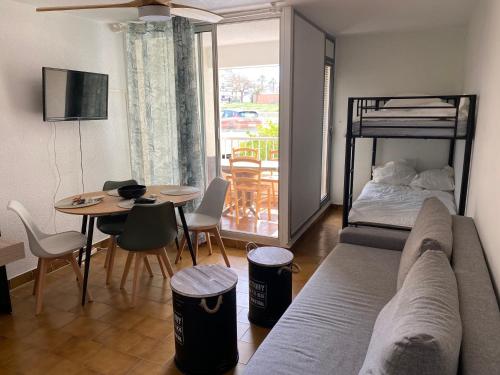 un salon avec un canapé, un lit et une table dans l'établissement Studio 4 personnes avec piscine au CAP D AGDE au pied du port et 5 mn à pied de la plage du Môle, au Cap d'Agde