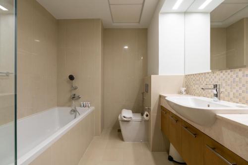 La salle de bains est pourvue d'un lavabo, d'une baignoire et de toilettes. dans l'établissement Lux BnB Bellevue Tower Burj Khalifa Views, à Dubaï