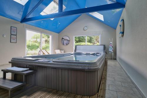 eine große Badewanne in einem Zimmer mit blauen Decken in der Unterkunft Beautiful villa with heated indoor pool, large garden close to beach, 8 people in Moëlan-sur-Mer