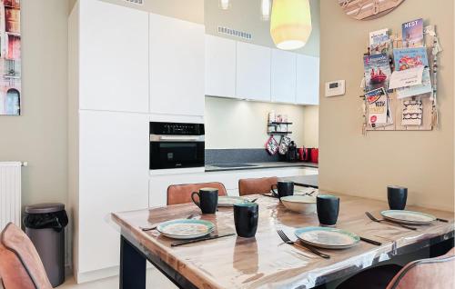 a kitchen with a wooden table with plates on it at Awesome Apartment In Oostende With Wifi in Ostend