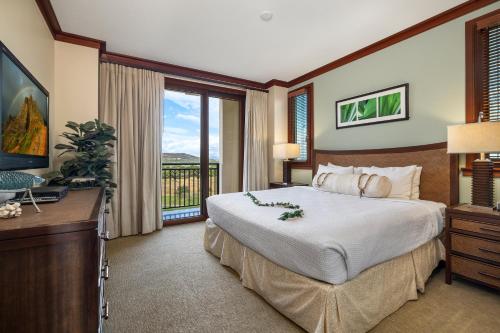 a bedroom with a large bed and a balcony at Ko Olina Beach Villas O1006 in Kapolei