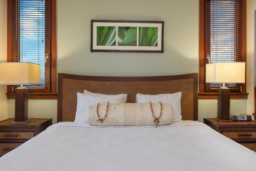 a bedroom with a bed with two lamps and two pillows at Ko Olina Beach Villas O1006 in Kapolei