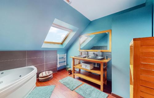 ein Badezimmer mit blauen Wänden, einer Badewanne und einem Spiegel in der Unterkunft Cozy Home In Saint-aubin-routot With Kitchen in Saint-Aubin-Routot