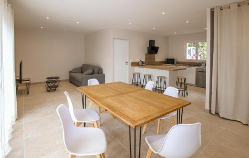 un salon avec une table en bois et des chaises blanches dans l'établissement Amazing Home In Lussas With Wifi, à Lussas
