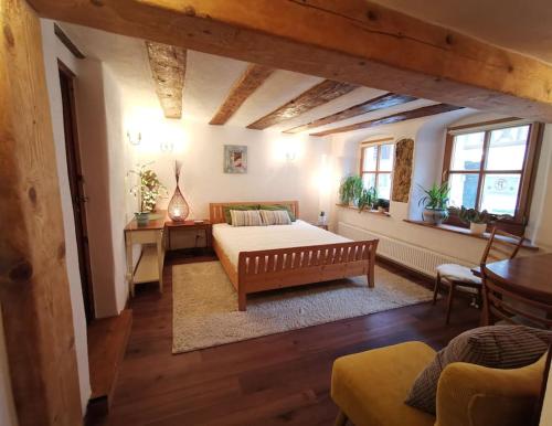 1 dormitorio con cama, mesa y ventanas en Charmantes Zimmer mit Bad im Stadtzentrum, en Pottenstein