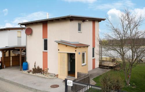 a white house with a red stripe at Ferienhaus Mit Seeblick in Rauchwart im Burgenland