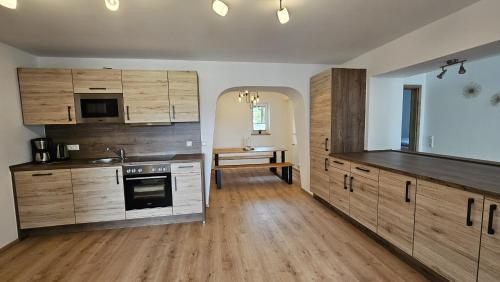 une cuisine avec des armoires en bois et une table à l'intérieur dans l'établissement wohnung-nummer-4, à Pielenhofen