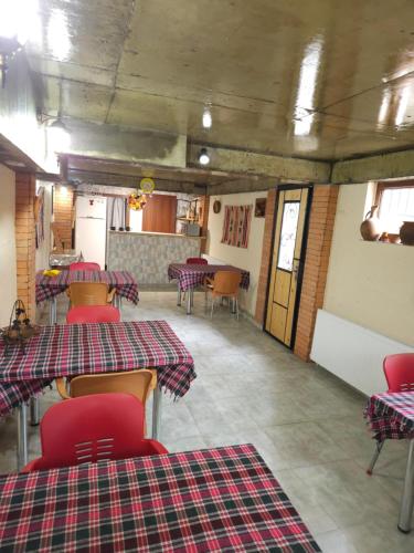 a restaurant with tables and chairs and a kitchen at Hotel Tradicia in Tbilisi City