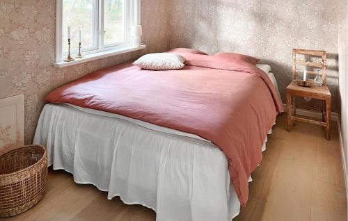 a bed with a pink blanket and a window at 3 Bedroom Beautiful Home In Sölvesborg in Sölvesborg