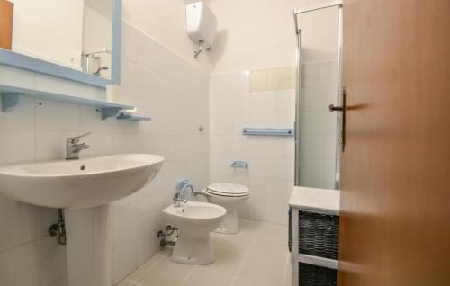Baño blanco con lavabo y aseo en Lovely Home In Arbus With Kitchen, en Arbus