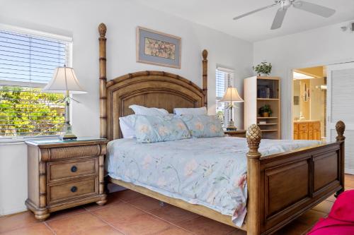 een slaapkamer met een groot bed met een houten hoofdeinde bij 105 Crimson Condos in St Pete Beach