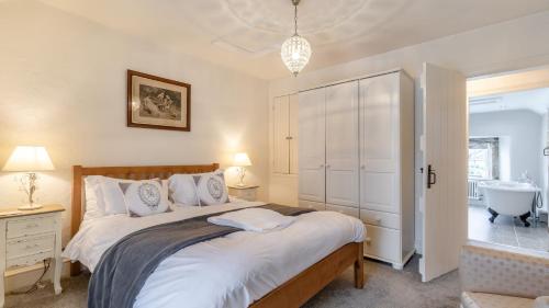 a bedroom with a large bed and a bathroom at Beech Cottage in Youlgreave