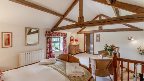 a bedroom with a large bed and a table at Wye Cottage near Hassop in Eyam
