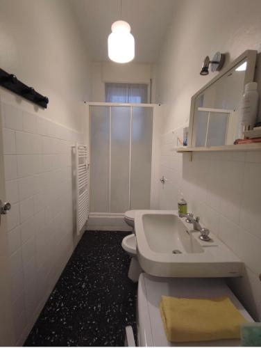 a bathroom with a sink and a toilet and a mirror at Gavirate House MM Lotto in Milan