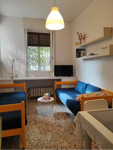 sala de estar con sofá azul y ventana en Gavirate House MM Lotto, en Milán