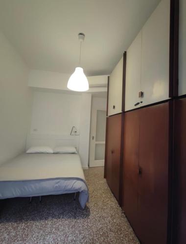 a bedroom with a bed and a cabinet and a light at Gavirate House MM Lotto in Milan