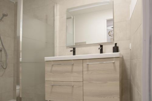 ein weißes Badezimmer mit einem Waschbecken und einem Spiegel in der Unterkunft Gîte le Luberon in Robion en Luberon