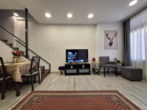 a living room with a television and a staircase at THOMAS LUXURY APARTMENT in the historical center of Ioannina in Ioannina