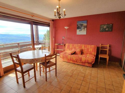 un salon avec un canapé et une table dans l'établissement Appartement 6 pers. proche station avec balcon et parking privatifs - FR-1-393-90, à Saint-Michel-de-Chaillol