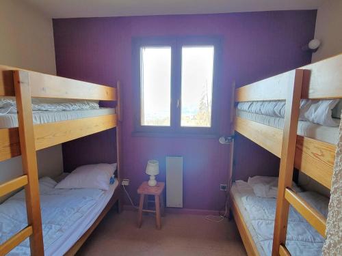 Dos literas en una habitación con ventana. en Appartement 6 pers. proche station avec balcon et parking privatifs - FR-1-393-90, en Saint-Michel-de-Chaillol