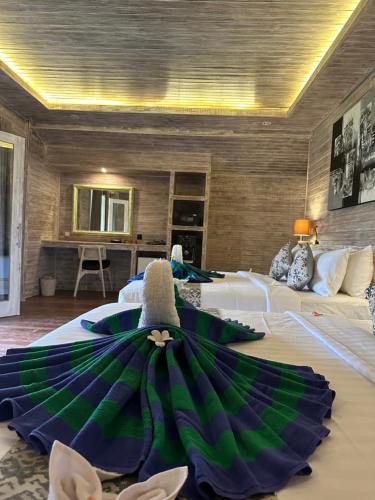 a hotel room with two beds with a green umbrella on the floor at The Niti Hut's Lembongan in Nusa Lembongan