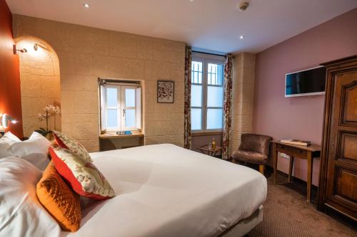 a hotel room with a large bed and a chair at Garlande Hôtel Avignon Centre in Avignon