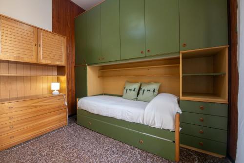 - une petite chambre avec des armoires vertes et un lit dans l'établissement 244 - Casa Ludo, Centro Storico,140m dalla Baia del Silenzio PATRIMONIO UNESCO spiaggia e mare, à Sestri Levante
