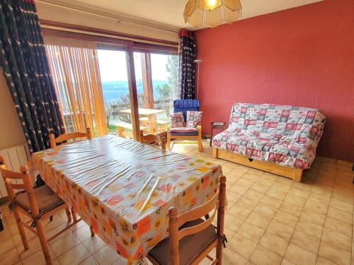 un salon avec une table et un canapé dans l'établissement Appartement cosy 5 pers, terrasse sud, parking, proche station, animaux acceptés - FR-1-393-127, à Saint-Michel-de-Chaillol