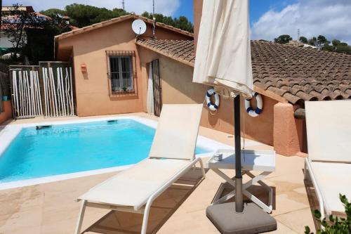 a patio with two chairs and an umbrella next to a pool at vistas y relax 126m privados con piscina No cocina in Costa del Maresme