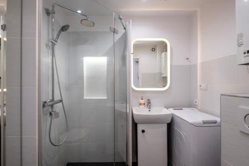 baño blanco con ducha y lavamanos en 28 Gdynia Centrum - Apartament Mieszkanie dla 2 os, en Gdynia