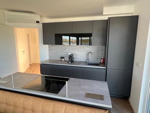 a kitchen with a sink and a refrigerator at Panorama Penthouse Punat in Punat