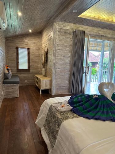 a bedroom with a bed and a large window at The Niti Hut's Lembongan in Nusa Lembongan