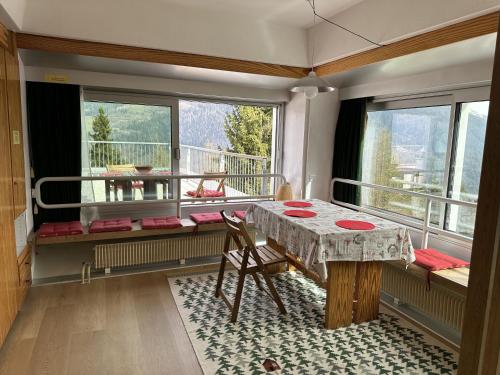 Camera con tavolo e balcone con finestre. di Bellavista Marilleva 1400 - Val di Sole a Marilleva