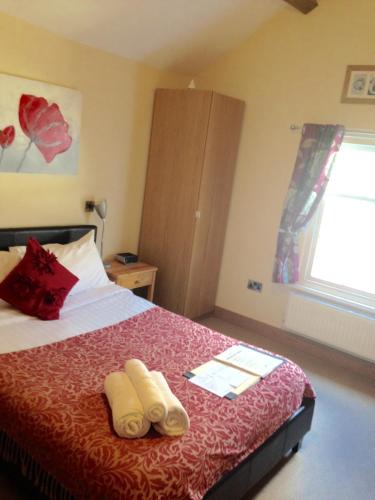 a bedroom with a bed with two towels on it at Bridge View Guest House in Ironbridge