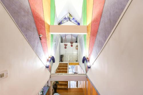 un couloir avec un plafond arc-en-ciel dans l'établissement OYO Nova Dumas Homestay, à Surate