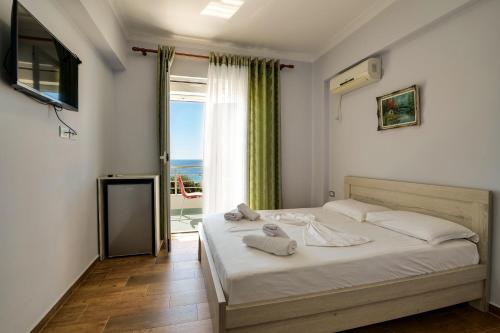 um quarto com uma cama e vista para o oceano em Hotel Billy em Himare